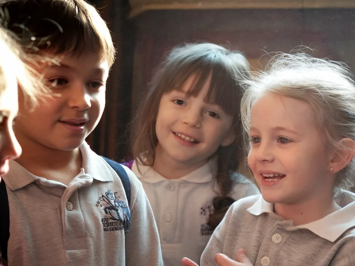 Children talking and laughing together in warm window light